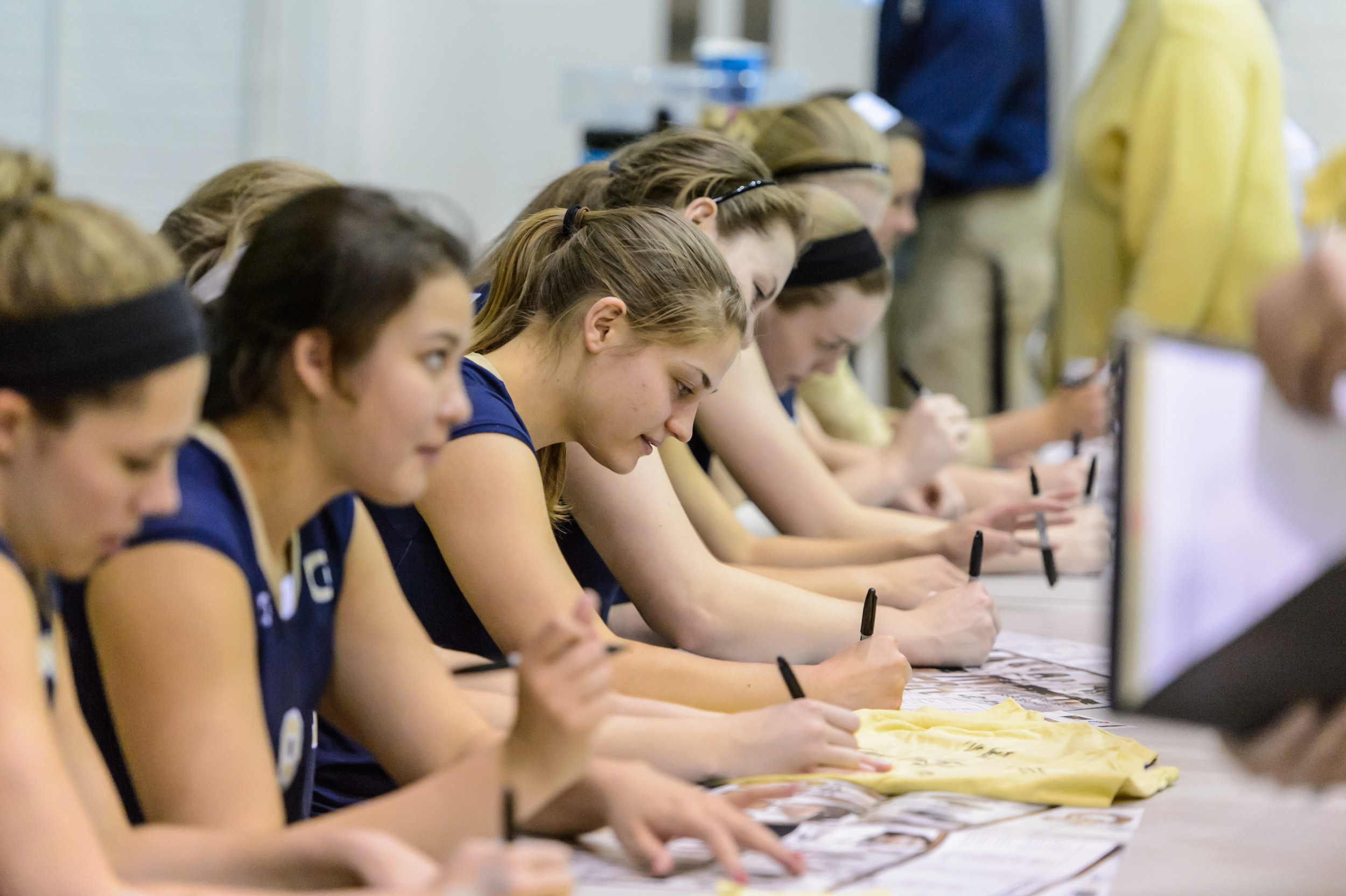 The team signs autographs after the game.