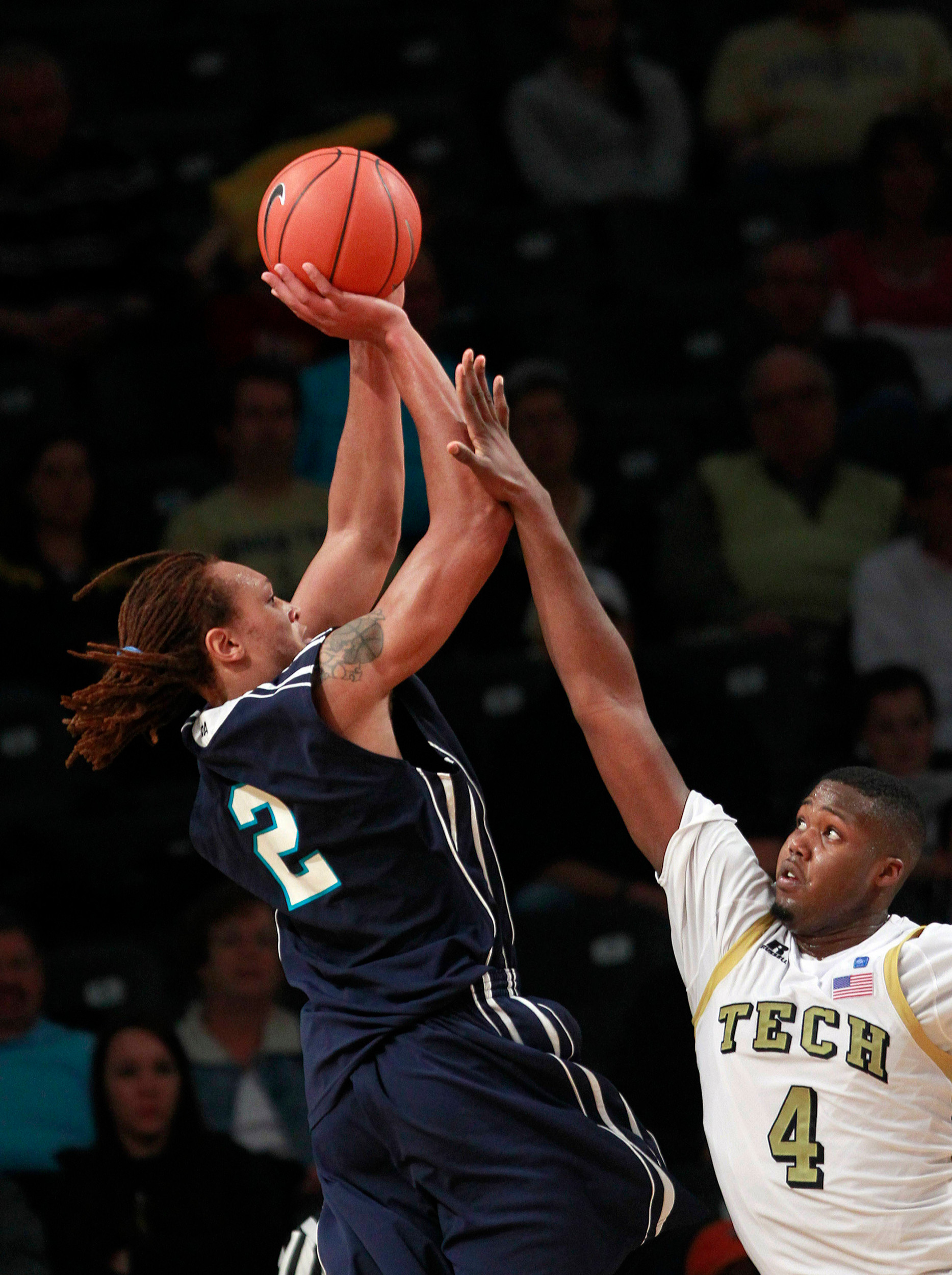 North Carolina-Wilmington forward Keith Rendleman (2) shots as Georgia Tech forward Robert Carter (4) defends in the first half. (AP Photo/John Bazemore)