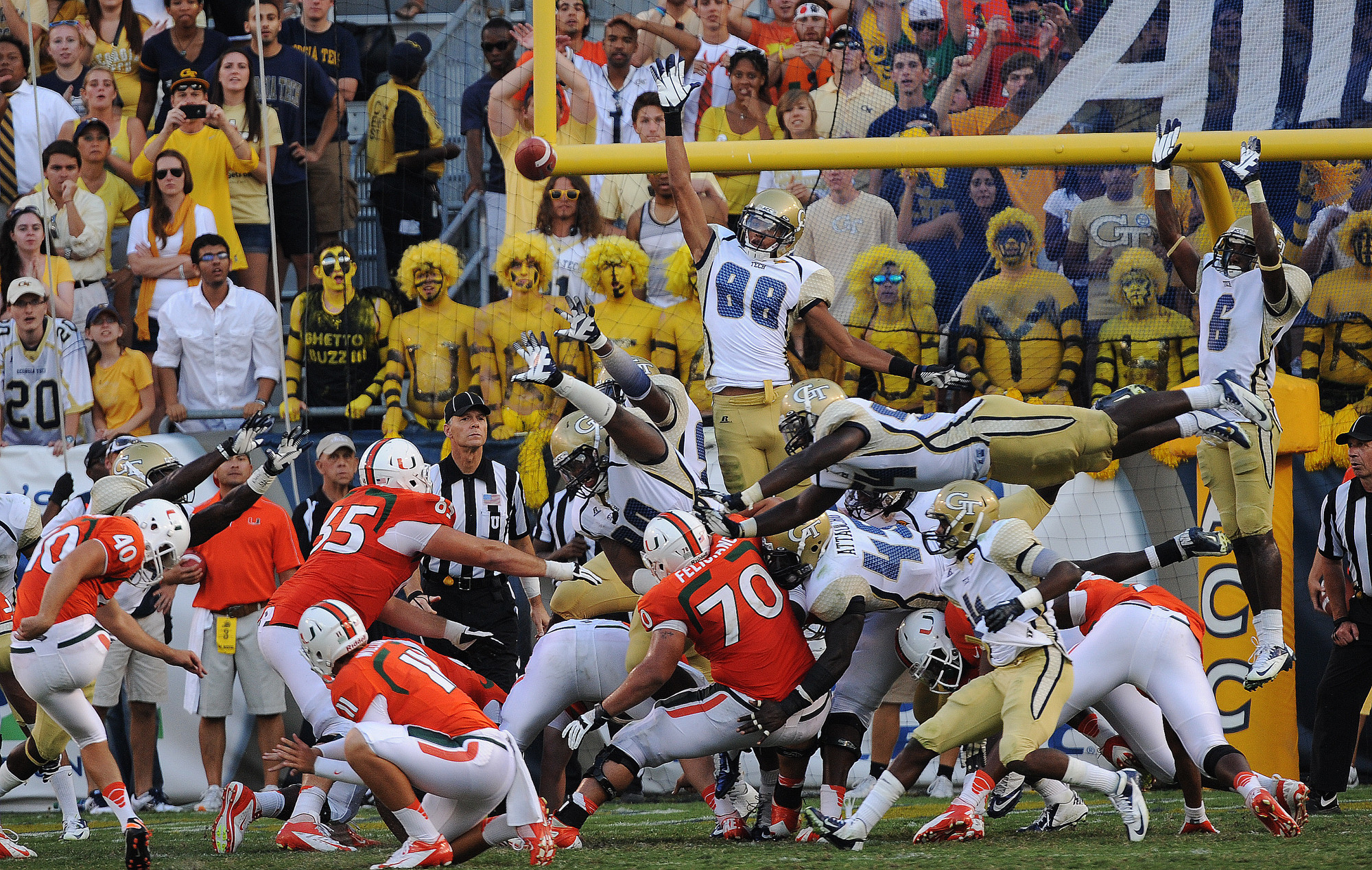 Georgia Tech players jump and fly through the air as they try to block a Miami field goal attempt to tie the game. (AP Photo/The Atlanta Journal-Constitution, Johnny Crawford)