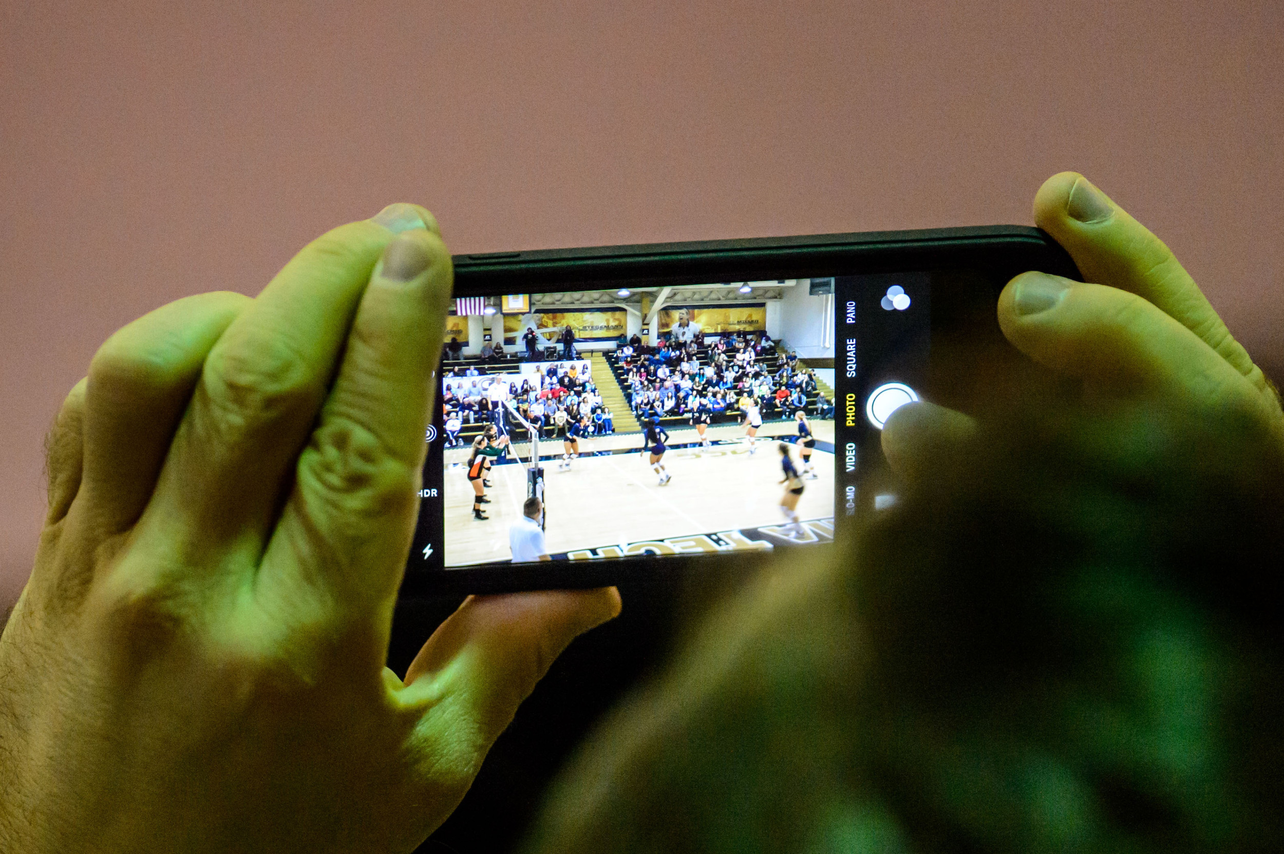 A fan takes a photo of the match