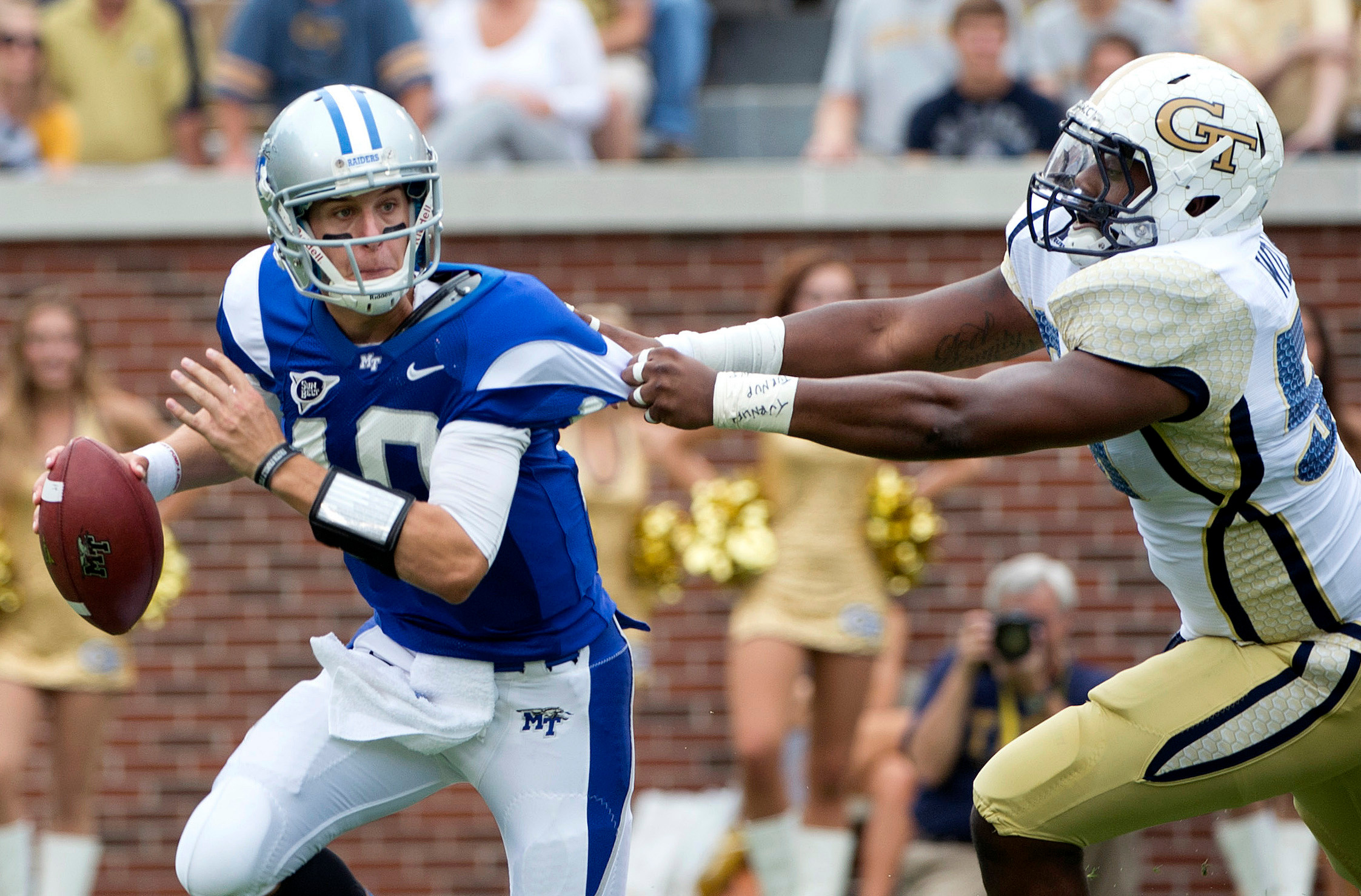 Middle Tennessee State quarterback Logan Kilgore, left, escapes the grasp of Georgia Tech defensive end Anthony Williams in the first half. (AP Photo/Rich Addicks)