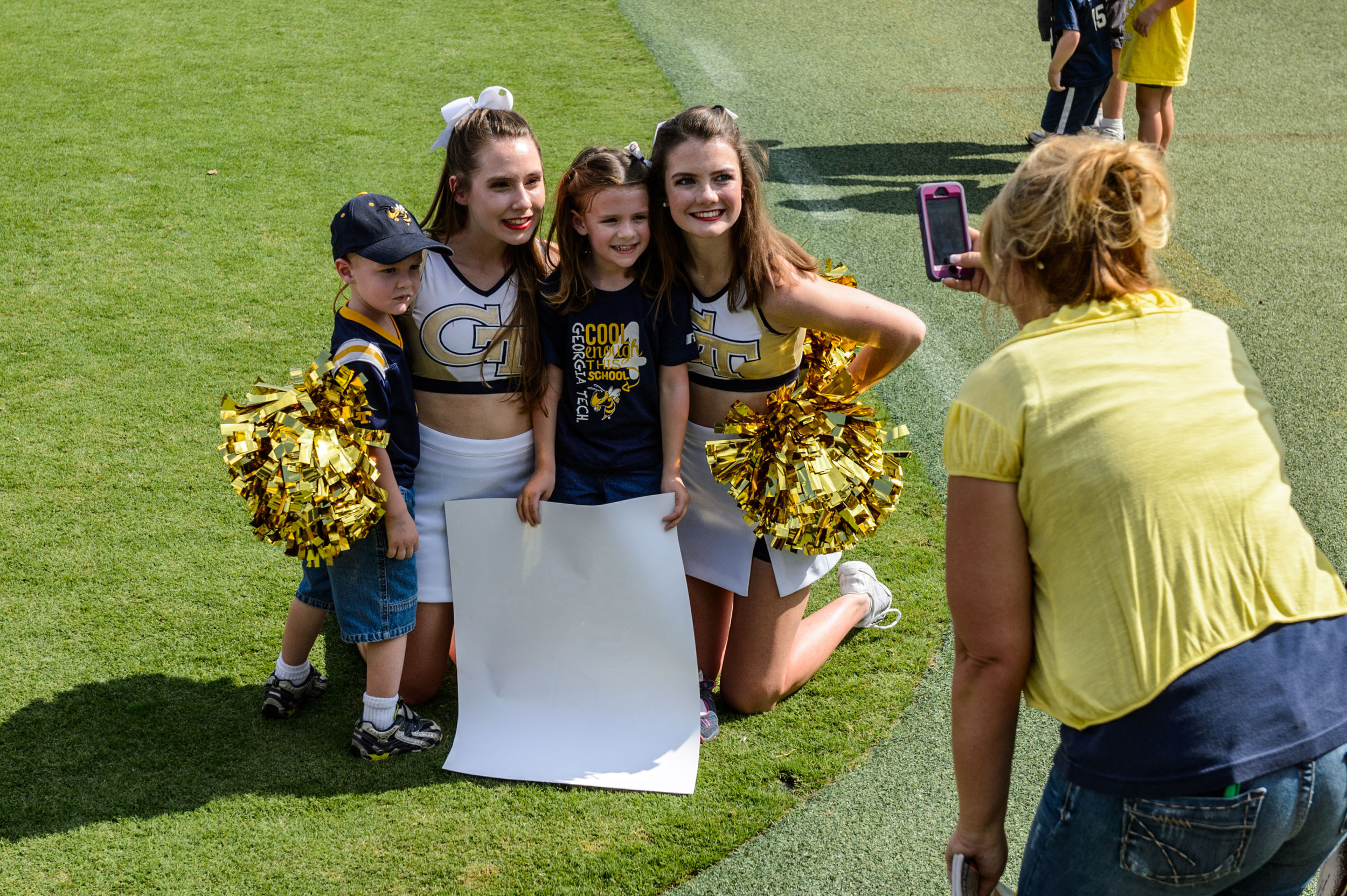 Cheerleaders pose with some young fans