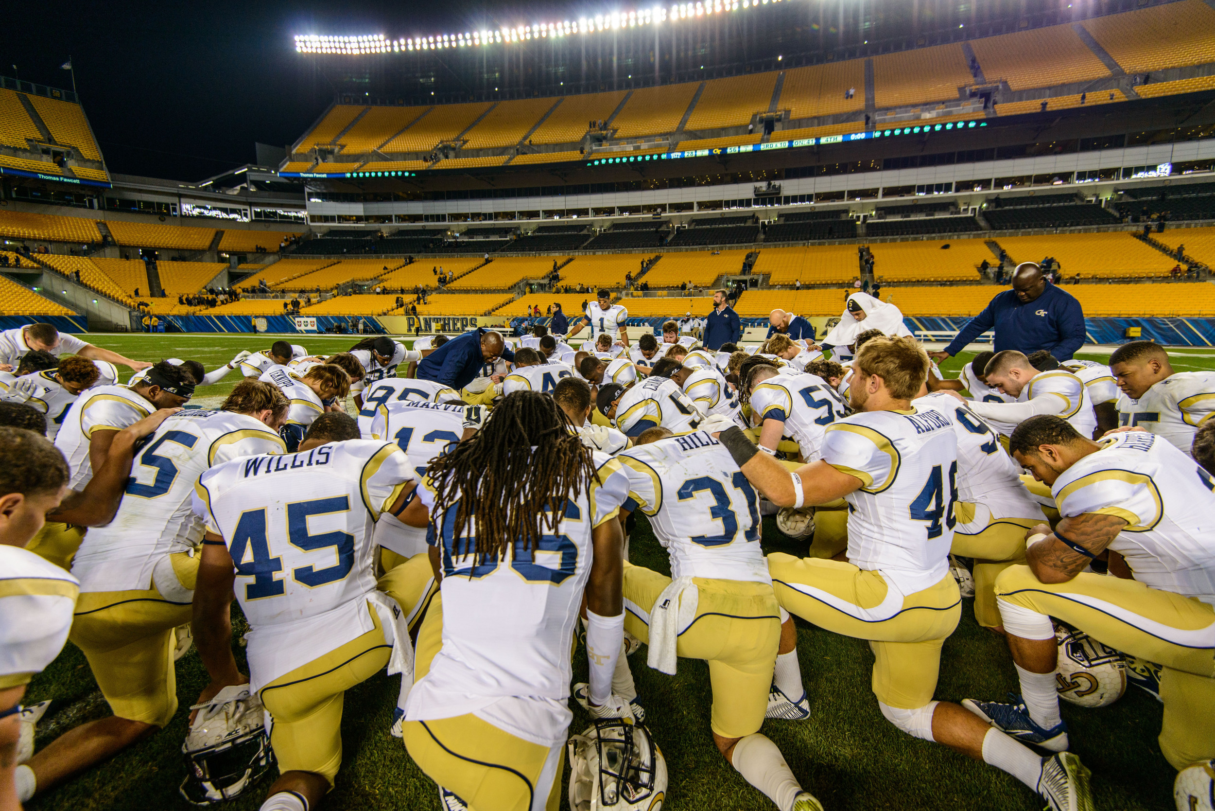 The team prays at midfield after the win