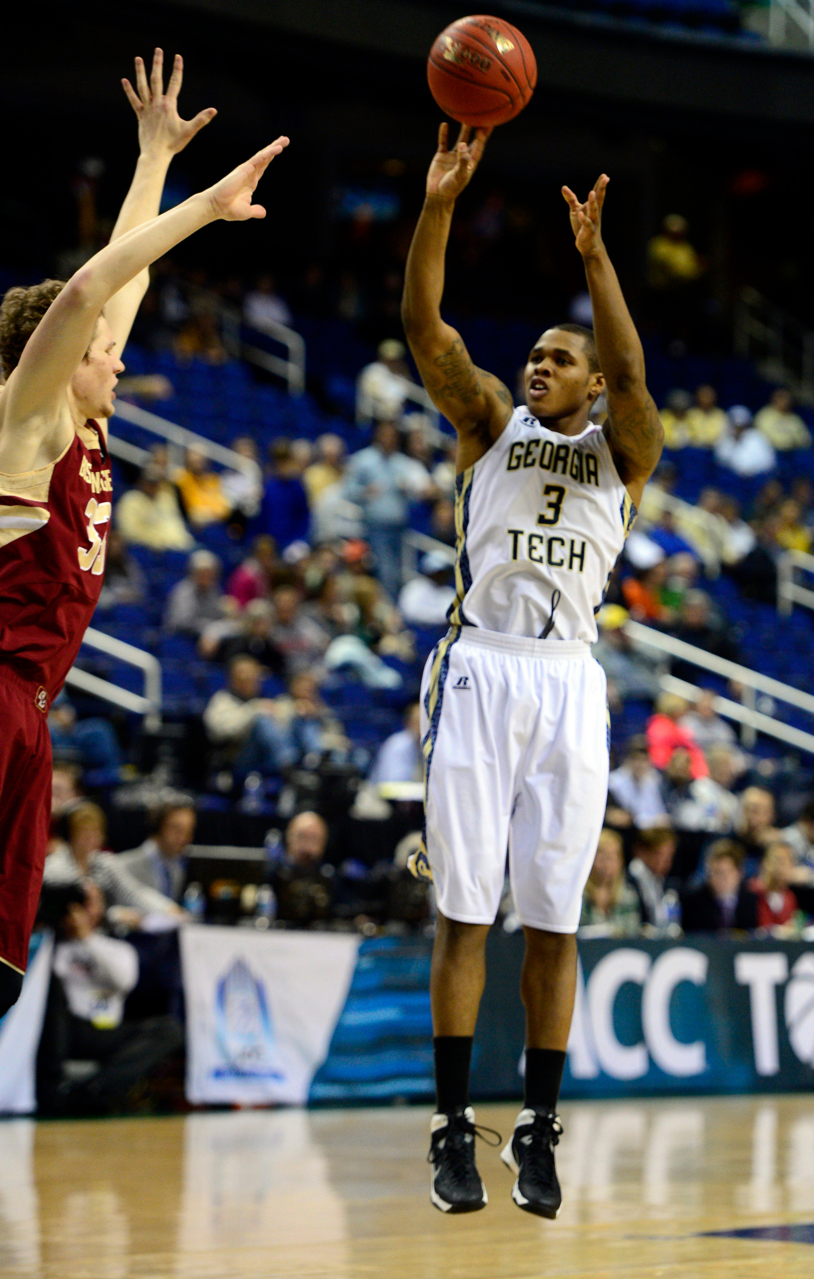 Mar 12, 2014; Greensboro, NC, USA; Georgia Tech Yellow Jackets forward Marcus Georges-Hunt (3) goes up for a jump shot against Boston College Eagles guard Patrick Heckmann (33) during the first round of the ACC Tournament at Greensboro Coliseum. Mandatory Credit: John David Mercer-USA TODAY Sports