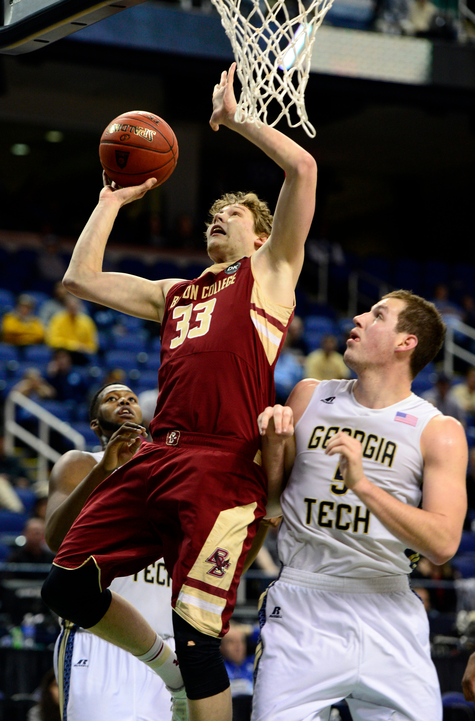Mar 12, 2014; Greensboro, NC, USA; Boston College Eagles guard Patrick Heckmann (33) goes up for a layup against Georgia Tech Yellow Jackets center Daniel Miller (5) in the second half during the first round of the ACC Tournament at Greensboro Coliseum. Georgia Tech defeated Boston College 73-70 in overtime. Mandatory Credit: John David Mercer-USA TODAY Sports