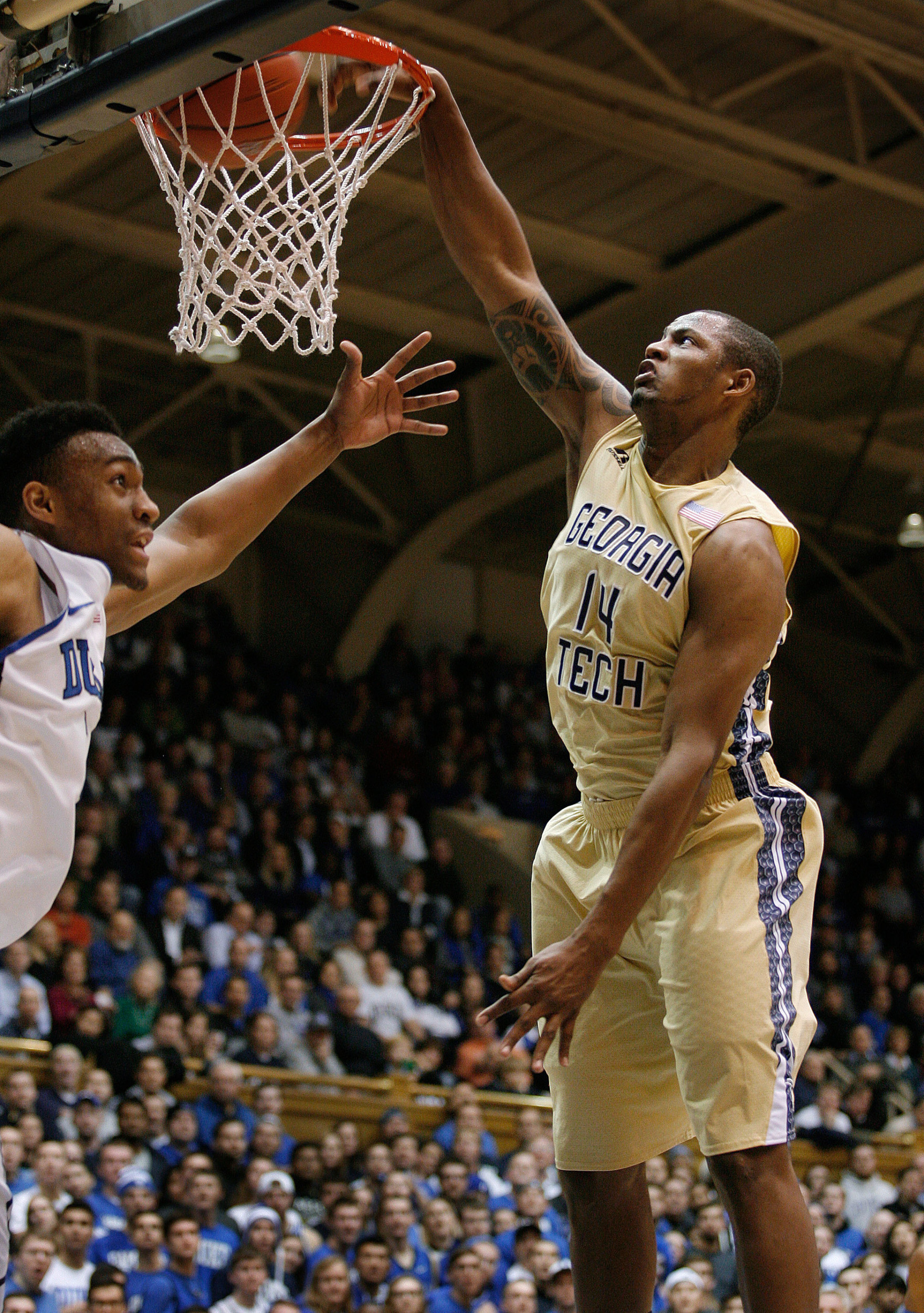 Jan 7, 2014; Durham, NC, USA; Georgia Tech Yellow Jackets guard/forward Jason Morris (14) dunks over Duke Blue Devils forward Jabari Parker (1) at Cameron Indoor Stadium. Mandatory Credit: Mark Dolejs-USA TODAY Sports