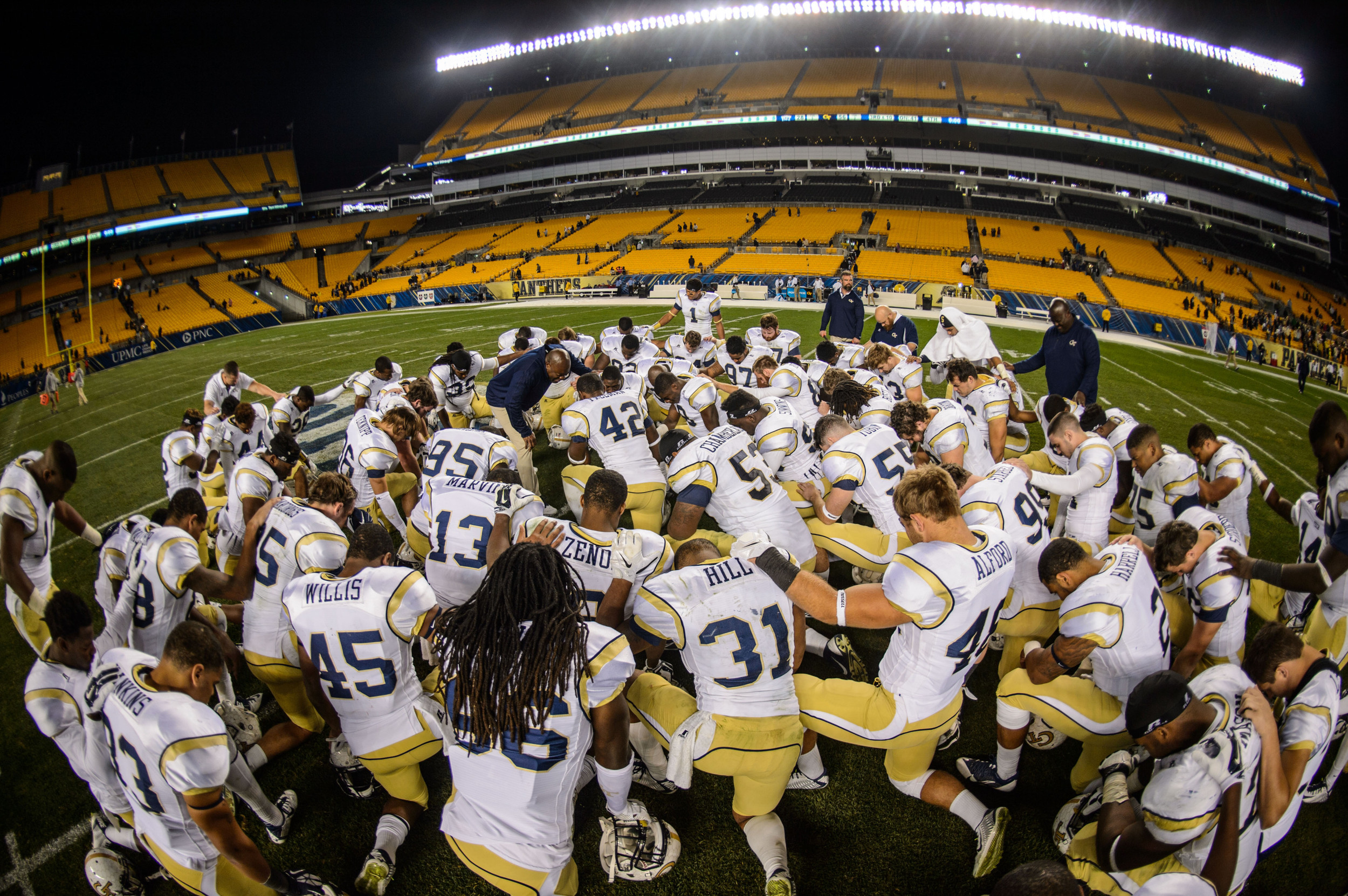 The team prays at midfield after the win