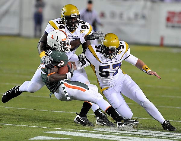 Elris Anyaibe (94) and Shane Bowen (57) bring down Miami's Graig Cooper. (Photo by LensEffects)
