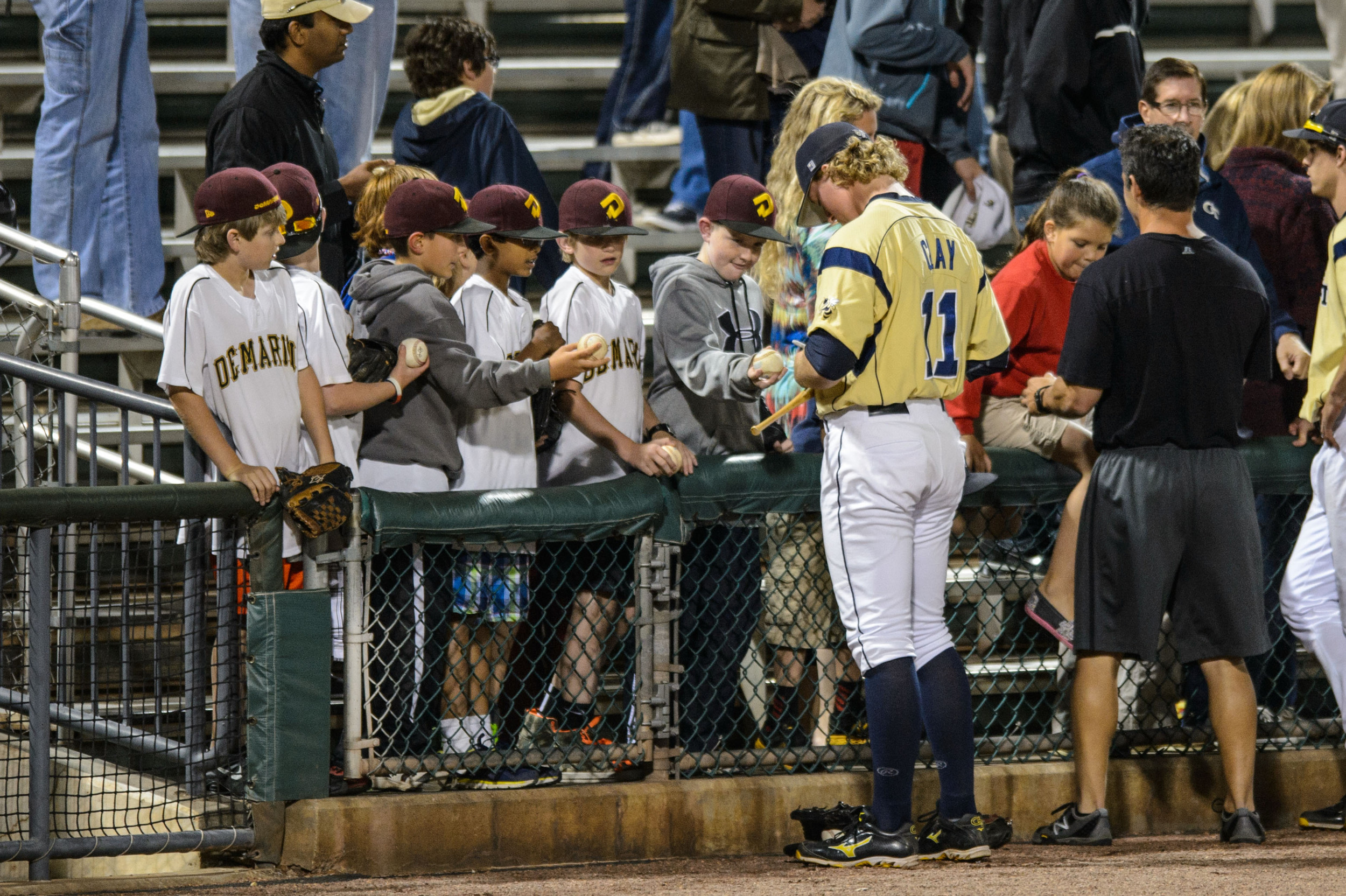 Sam Clay (11) signs autographs for young Yellow Jacket fans after the game