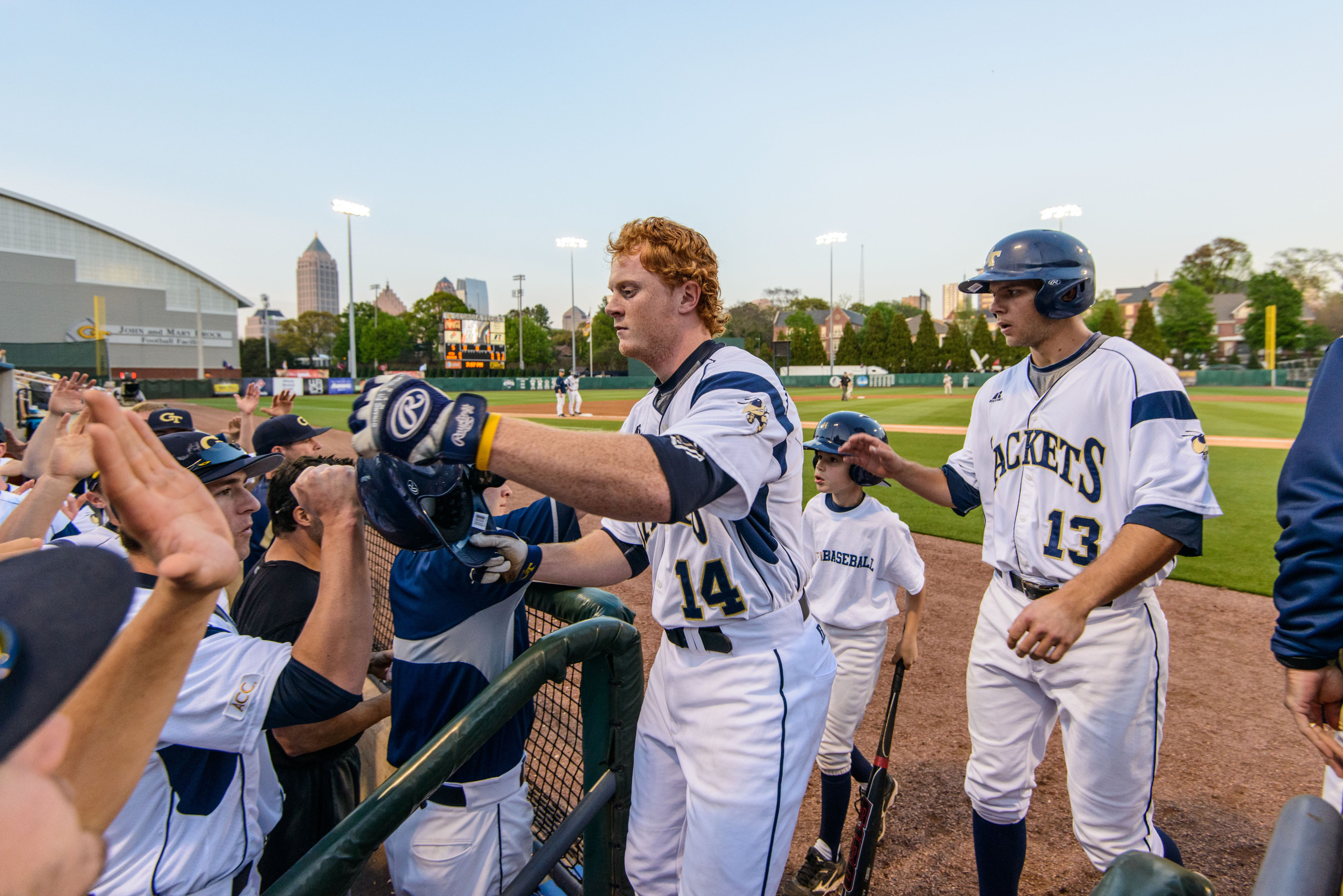 Matt Gonzalez (14) and Thomas Smith (13) are welcomed back to the dugout after scoring runs