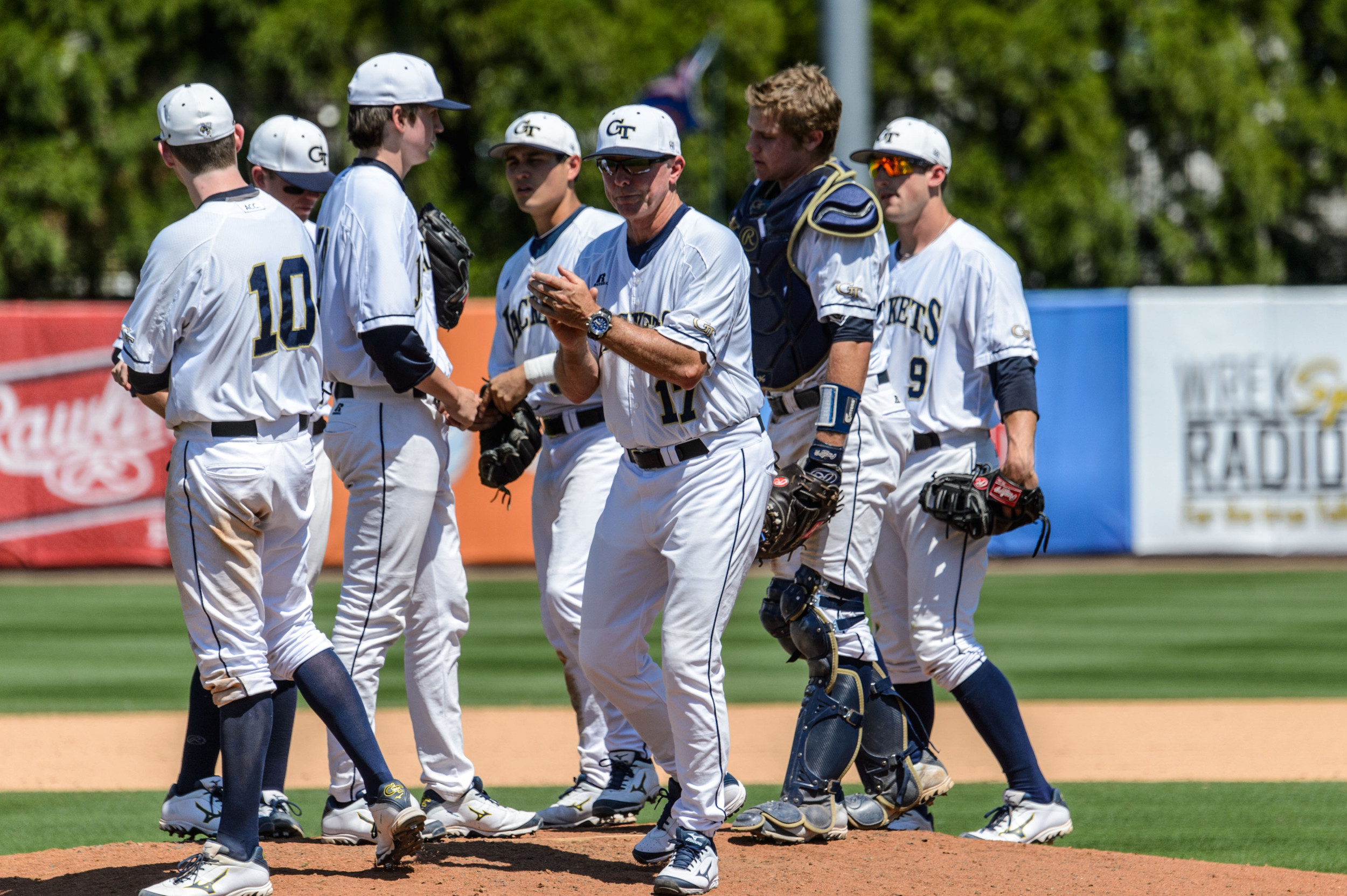 Coach Danny Hall (17) leaves the mound after a pitching change