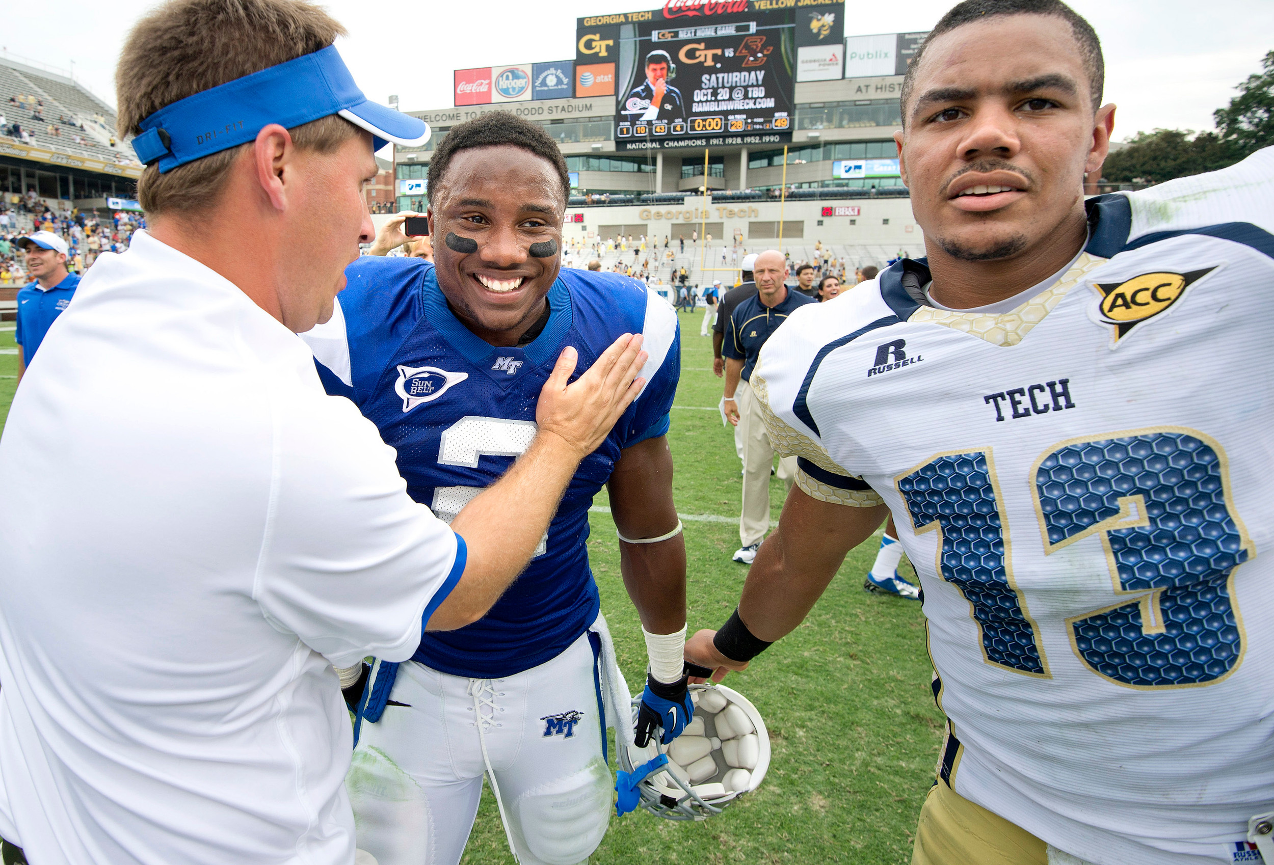 Middle Tennessee State running back Benny Cunningham, center, is congratulated by an unidentified Middle Tennessee State coach and Georgia Tech quarterback Tevin Washington. (AP Photo/Rich Addicks)