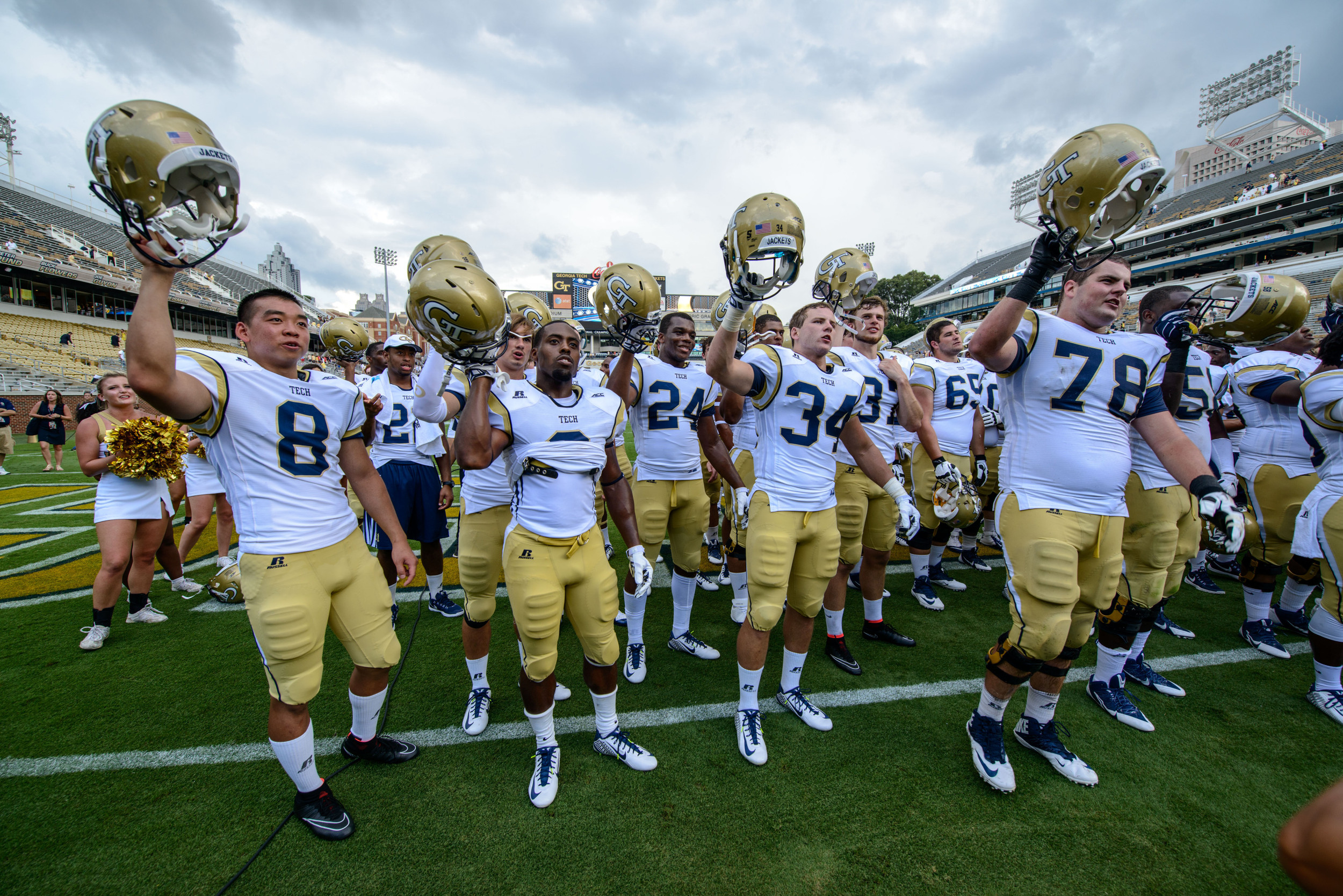 The team sings the fight song with the fans after the win