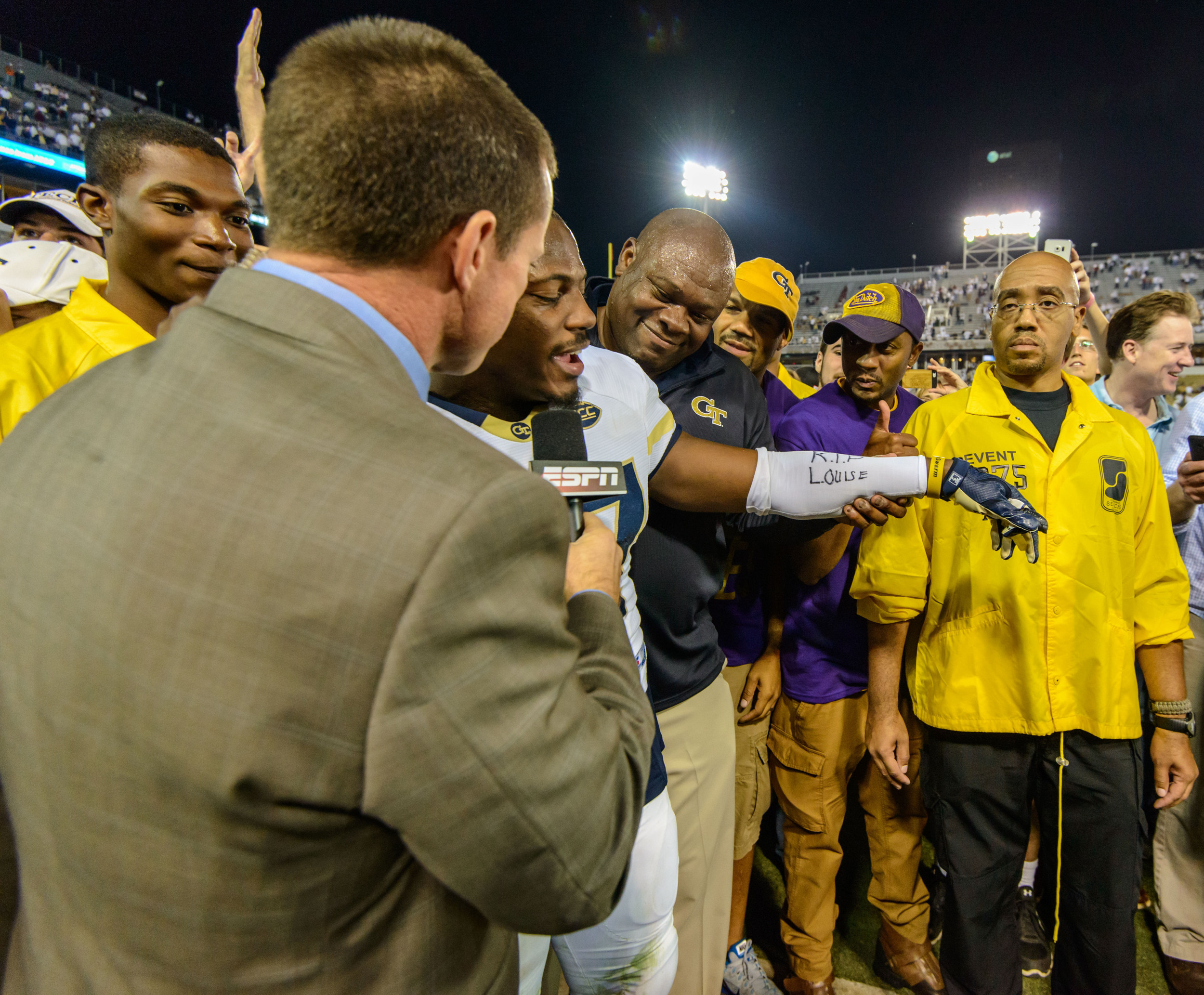 Lance Austin (17) is interviewed on ESPN as Team Chaplain Derrick Moore stands by his side