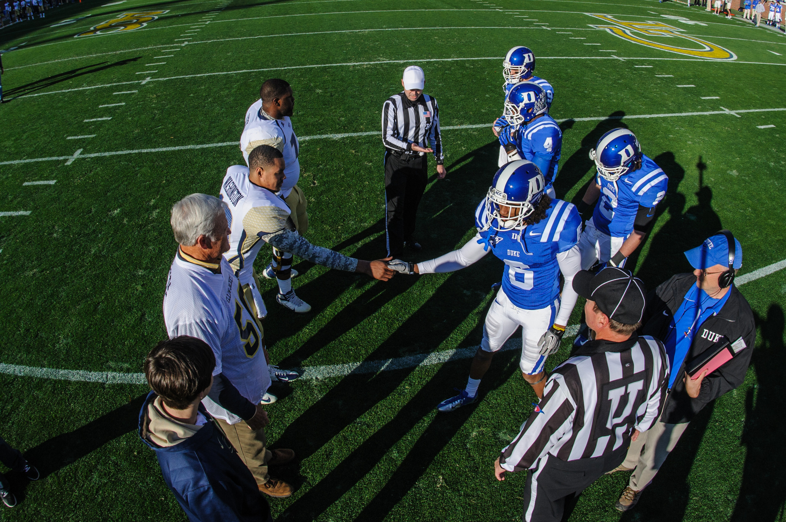Captains Omoregie Uzzi (77) and Tevin Washington (13) meet the Duke captains at midfield for the coin toss.