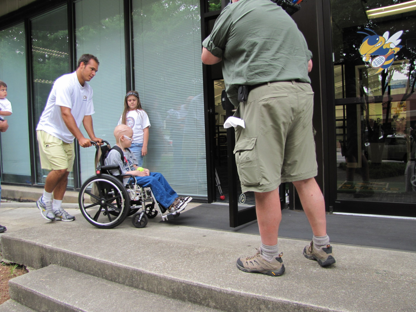 Guillermo Gomez takes Nolan into the tennis center for his adoption party.