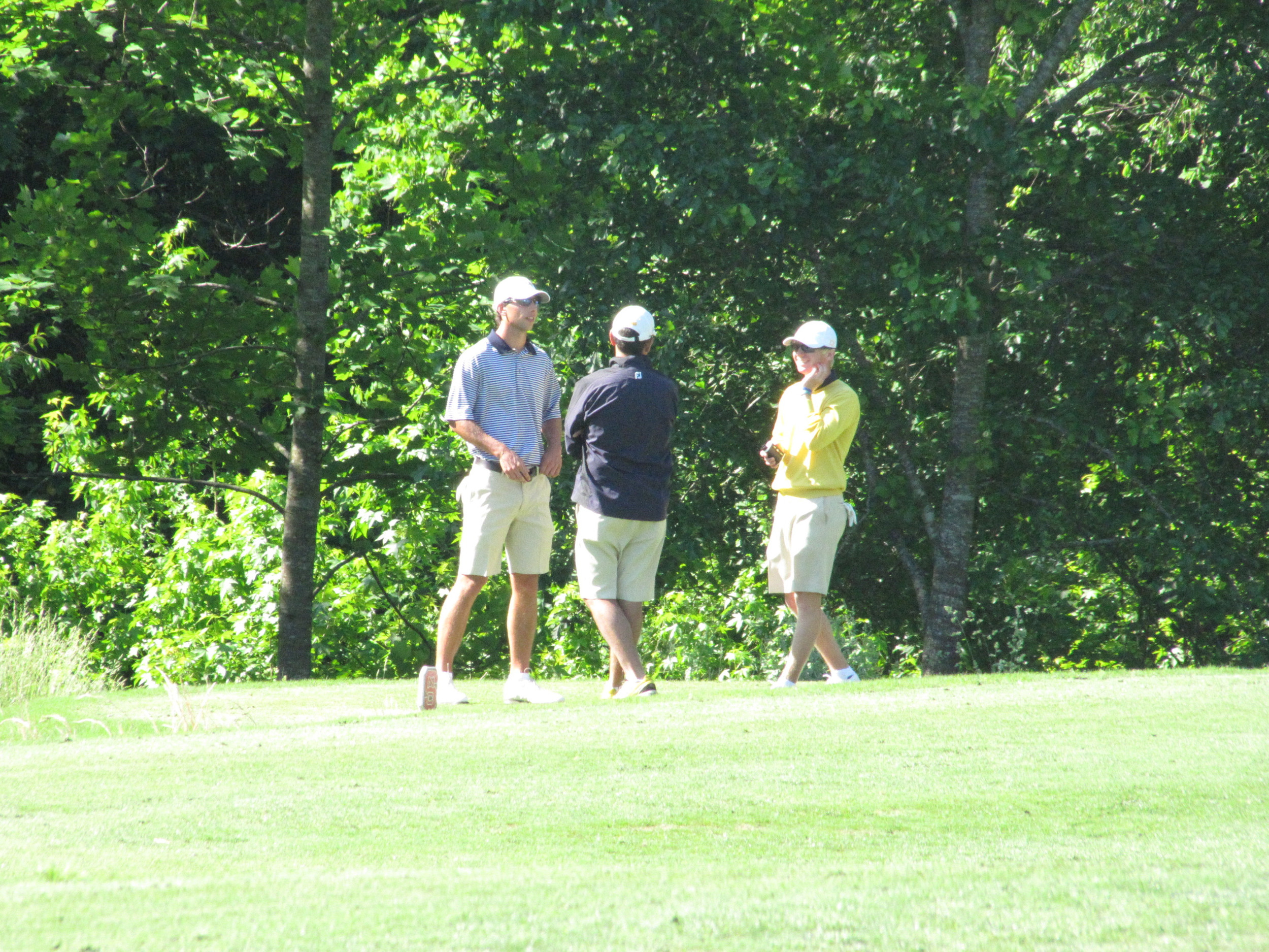 Seth Reeves, assistant coach Brennan Webb and Anders Albertson gather on the 2nd tee during a back up on Saturday at the NCAA Raleigh Regional.