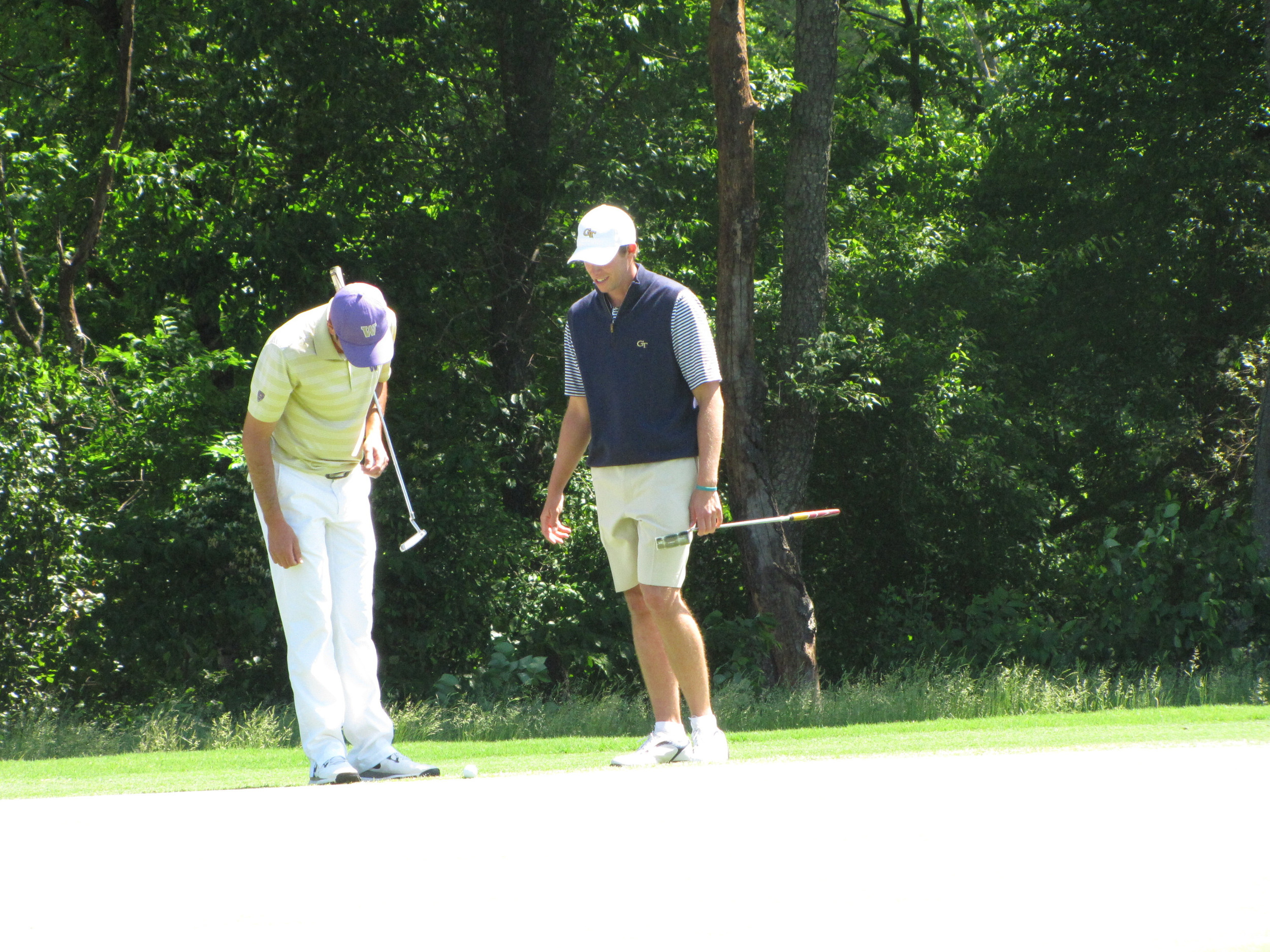 Bo Andrews checks out his lie at the 6th green with a playing partner during the final round of the NCAA Raleigh Regional.