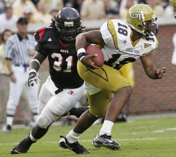 Georgia Tech quarterback Calvin Booker (18) evades Gardner Webb defensive end Kenny Baker (31) during the third quarter.
