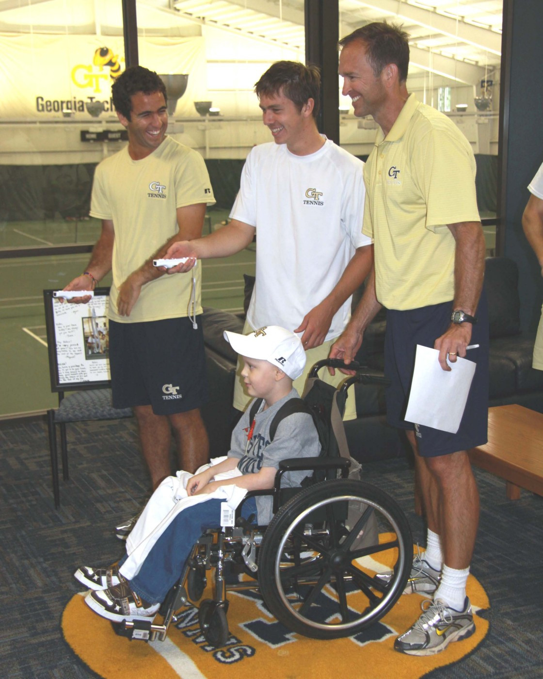 Magin Ortiga, Eliot Potvin and Kenny Thorne get Nolan ready for a game of Wii Tennis.
