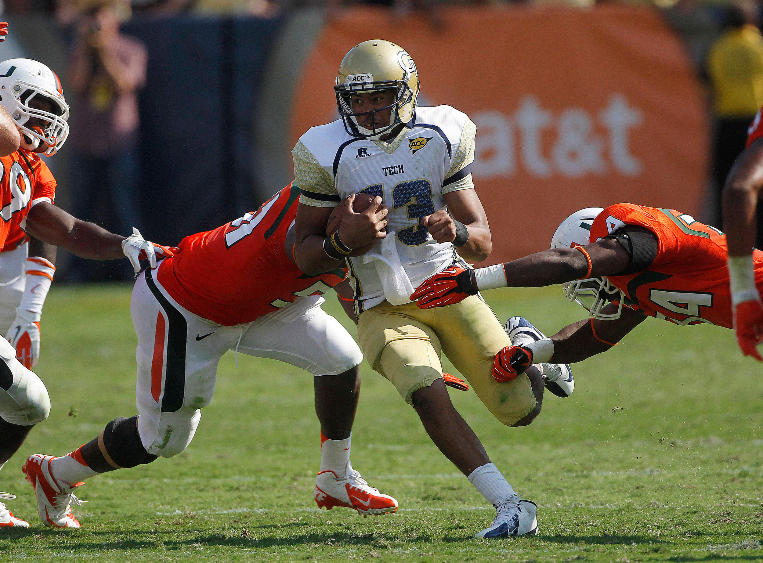 Georgia Tech quarterback Tevin Washington (13) is stopped by Miami defensive lineman Shayon Green (51) and linebacker Thurston Armbrister (34) in the first half of an NCCA college football game in Atlanta on Saturday, Sept. 22, 2012. (AP Photo/John Bazemore)