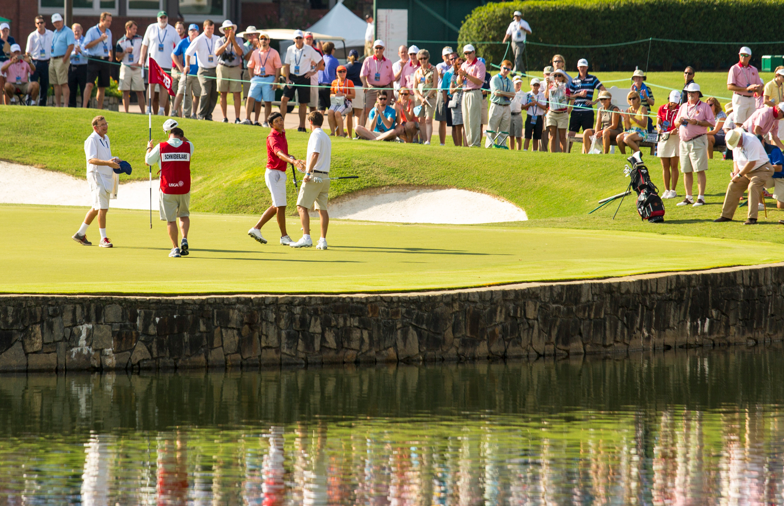 Gunn Yang shakes hands Ollie Schniederjans on the 18th hole during the third round of match play at the 2014 U.S. Amateur at Atlanta Athletic Club in Johns Creek, Ga. on Thursday, Aug. 14, 2014. (Copyright USGA/John Mummert)