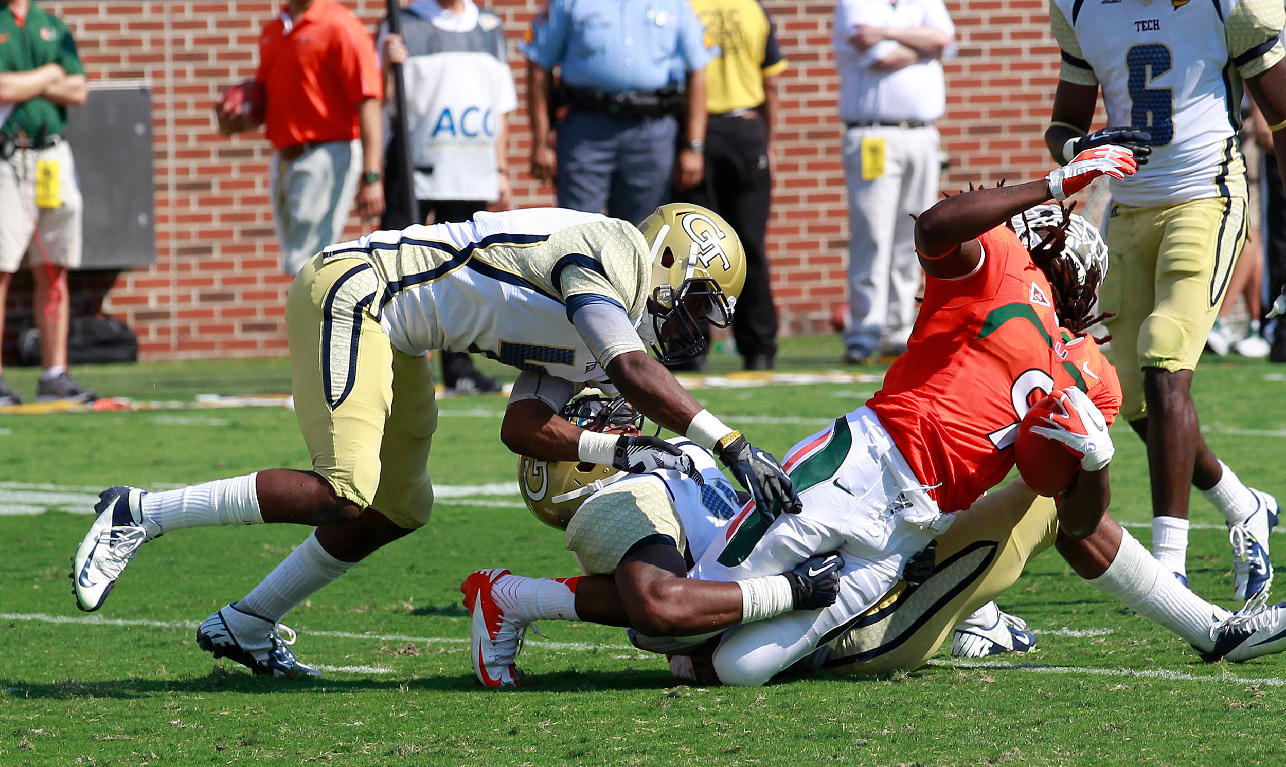 Miami wide receiver Malcolm Lewis (9) is tackled by Georgia Tech linebacker Brandon Watts (11) and defensive back Jamal Golden (4) after a catch in the first half of an NCAA college football game in Atlanta on Saturday, Sept. 22, 2012. Lewis was injured on the play and had to be taken off the field on a cart. (AP Photo/John Bazemore)