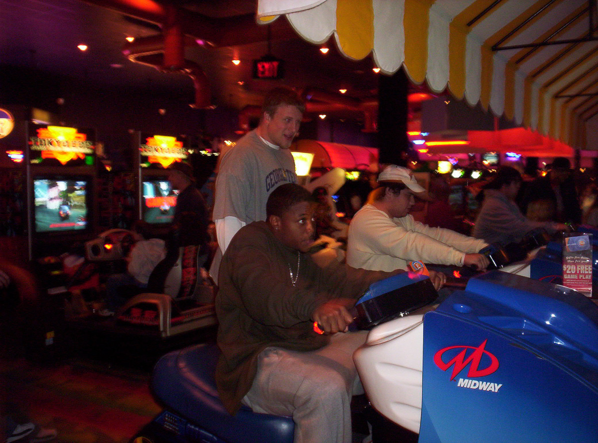Tashard Choice races a car while teeammate Mike Cox watches at Dave and Buster's.