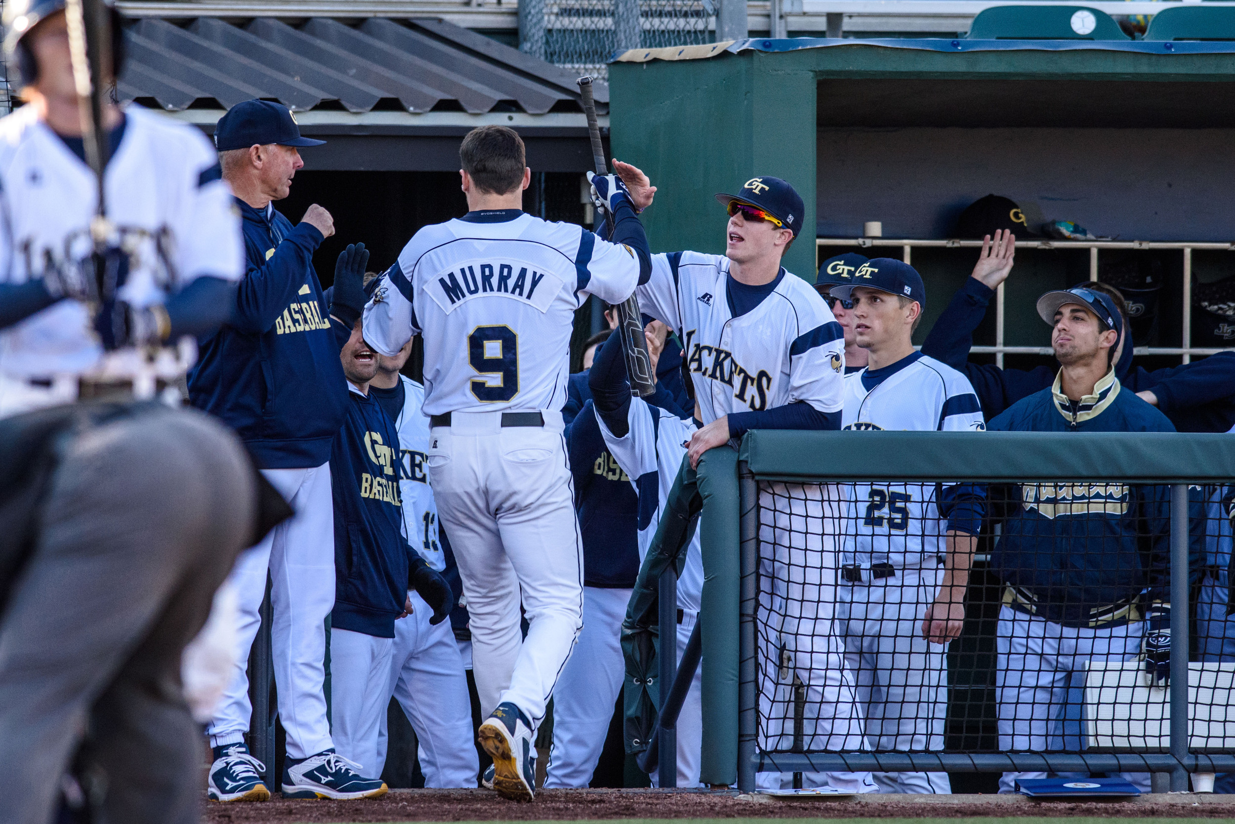 A.J. Murray (9) is congratulated by teammates upon returning to the dugout after his homerun