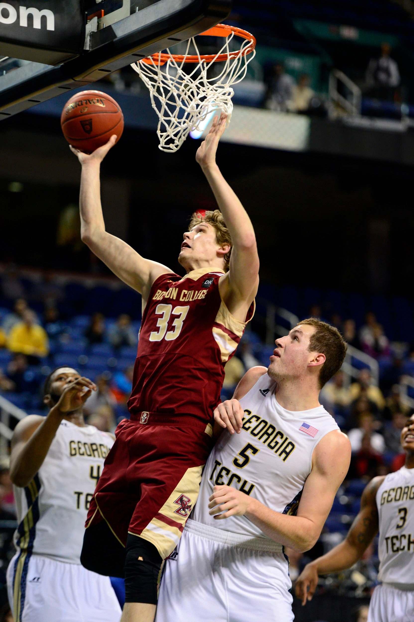 Mar 12, 2014; Greensboro, NC, USA; Boston College Eagles guard Patrick Heckmann (33) goes up for a layup against Georgia Tech Yellow Jackets center Daniel Miller (5) in the second half during the first round of the ACC Tournament at Greensboro Coliseum. Georgia Tech defeated Boston College 73-70 in overtime. Mandatory Credit: John David Mercer-USA TODAY Sports