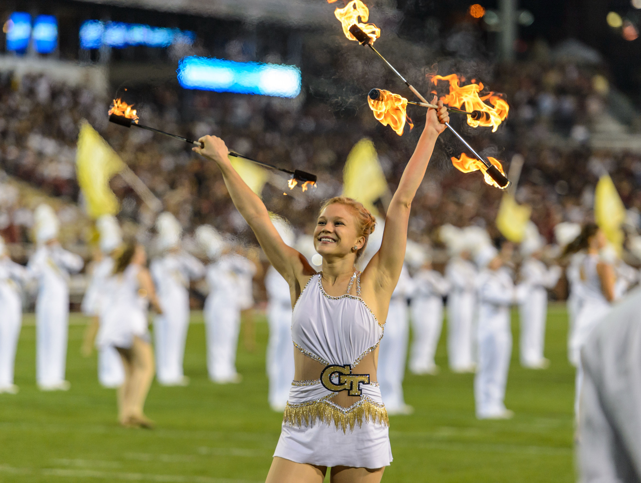 The Georgia Tech Golden Girl twirls fire during halftime