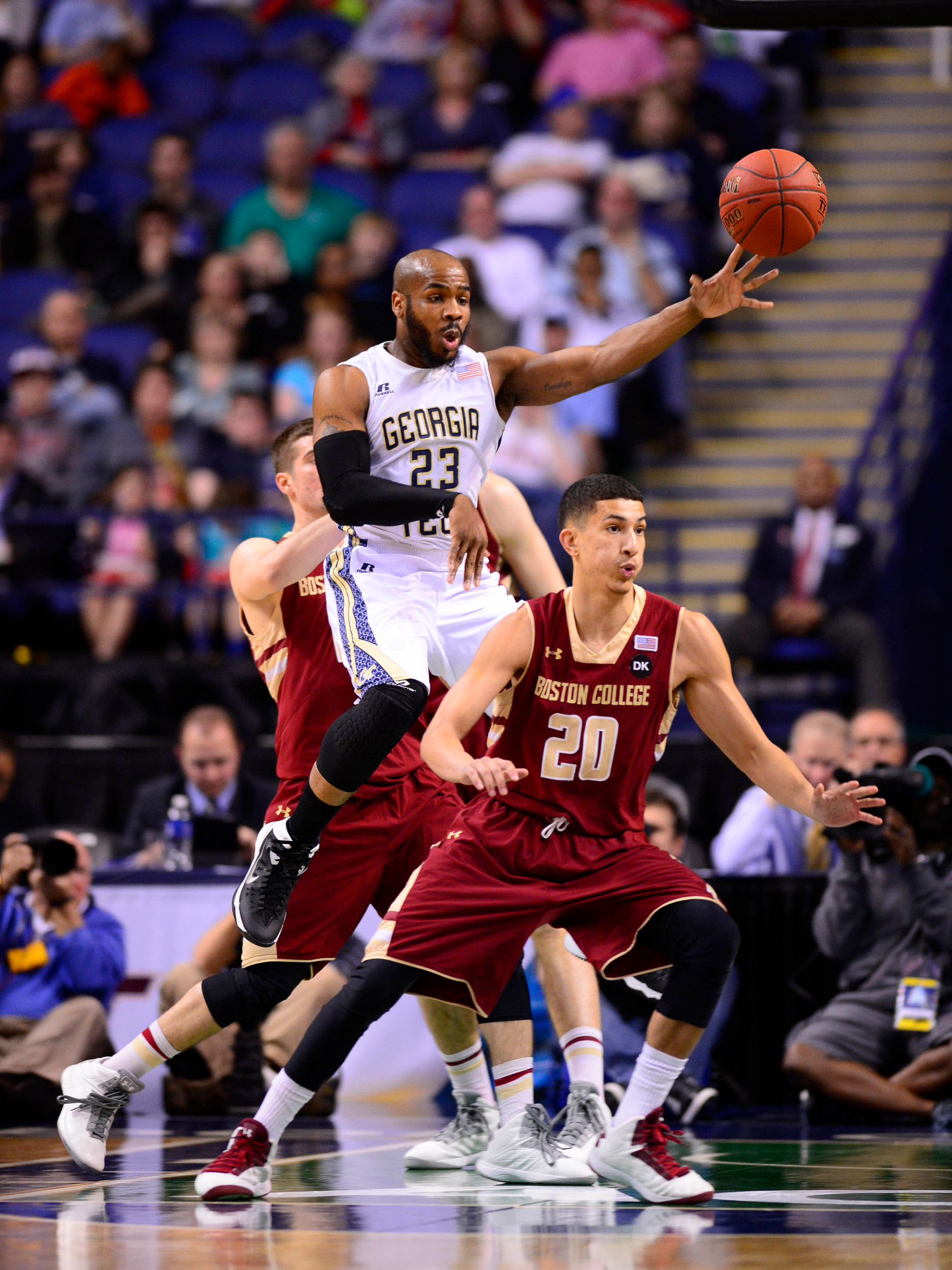 Mar 12, 2014; Greensboro, NC, USA; Georgia Tech Yellow Jackets guard Trae Golden (23) passes the ball as Boston College Eagles guard Joe Rahon (25) and guard Lonnie Jackson (20) defend in the first half in the first round at Greensboro Coliseum. Mandatory Credit: Bob Donnan-USA TODAY Sports